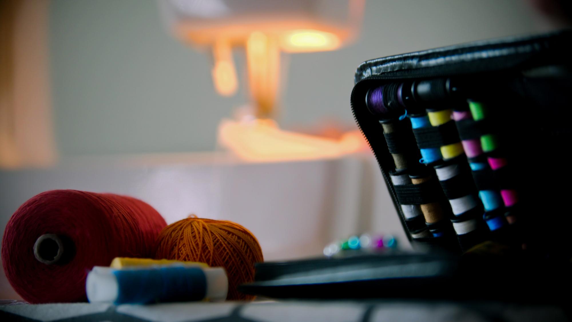Studio workspace with embroidery machine and laptop